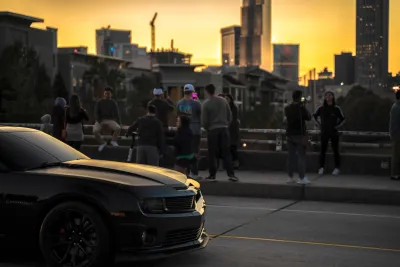 People standing at railing of Jackson Street Bridge in Atlanta at sunset overlooking downtown skyline.