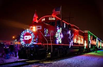 Train locomotive decorated with lights and snowfkale symbols for Christmas at night.