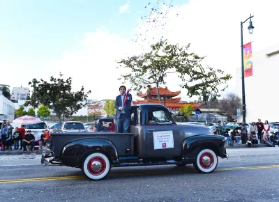 US Representative Jimmy Gomez rides in a black vintage truck in Los ANgeles Chinese New Year parade.