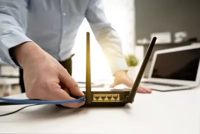 Man plugging cable into home modem