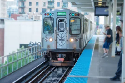 Silver CTA train pulling into elevated platform station in Chicago, Illinois.