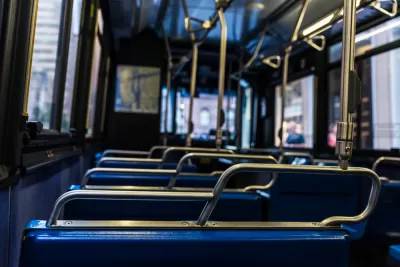 Close-up view of empty bus from behind seat. Seats have blue upholstery