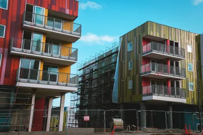 Green and red modern multistory apartment buildings under construction in Los Angeles.