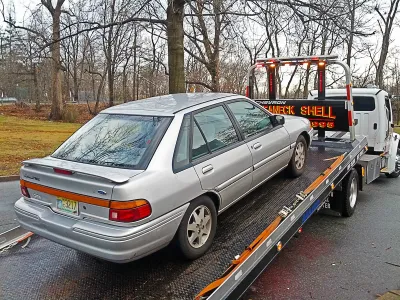Silver car on back of tow truck.