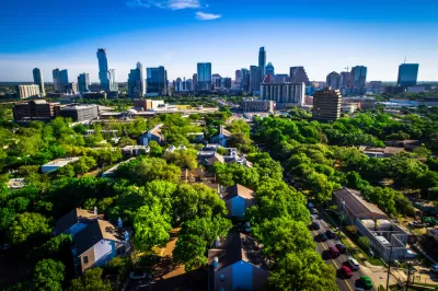 Aerial view of green trees over residential neighborhood with Austin, Texas skyline in the background