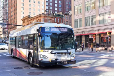 White public bus on street in Baltimore, Maryland with brick buildings in background