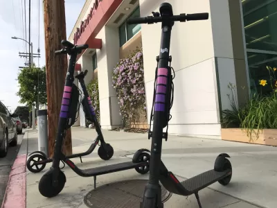 Three Lyft electric scooters parked on a sidewalk in West Los Angeles