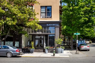 Cafe on corner of small street with leafy trees on sunny day in Seattle, Washington.