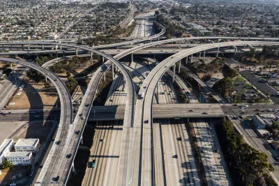 Aerial of ramps, bridges and traffic on the Harbor 110 and Century 105 freeway interchange in Los Angeles. The main road splits off in opposite directions midway through the photo. 