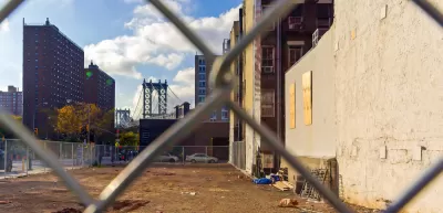 View of vacant lot in Manhattan through chain link fence