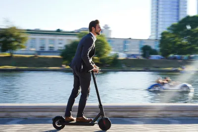 A businessman rides an e-scooter