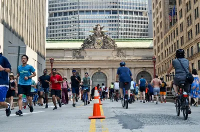 People walking and biking on street in front of Grand Central Terminal in New York City.