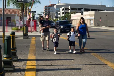 Family with three small children crossing the street in Bakersfield, California.