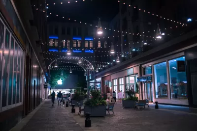 Nighttime view of pedestrianized street in Bethesda, maryland with benches and people walking
