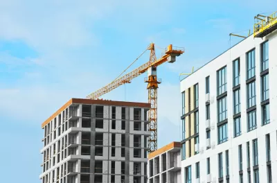 Apartment buildings under construction with crane.