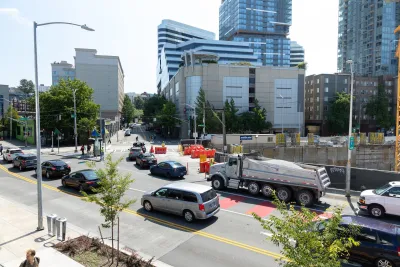 Traffic on Denny Way in Seattle with downtown buildings in background.