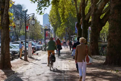 People walking and biking on sidewalk in Dusseldorf, Germany.