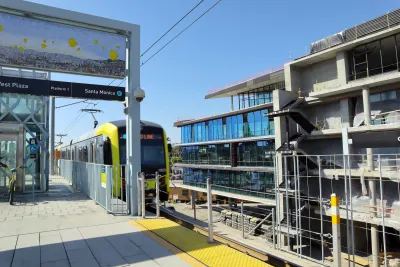 Yellow and black light rail train pulling into elevated station in Culver City, California.