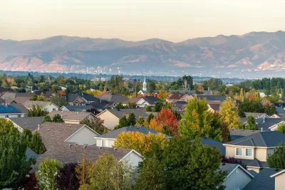 View of residential neighborhood with large trees and mountains in background in Salt Lake City, Utah.