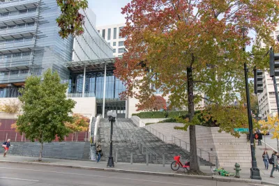 Seattle City Hall facade with stairs up to building and red and orange fall leaves on trees.