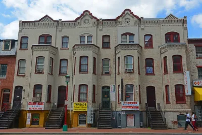Three-story white brick residential buildings with retail on ground floor/basements in Washington D.C.