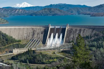 Shasta Dam with deep turquoise water in reservoir behind it in northern California.