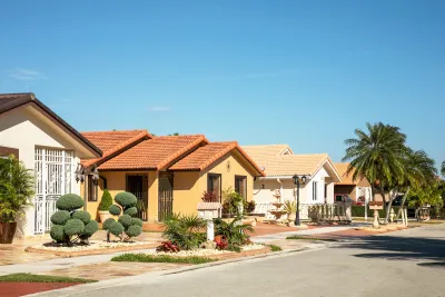 Small Spanish-style homes on residential street in Florida on a sunny day.