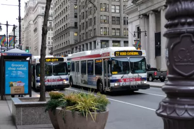 Two white SEPTA buses with red and blue lines on urban Philadelphia street