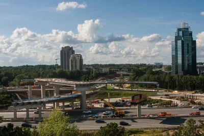 Highway overpasses eith four high-rise buildings sparsely arranged in background in Atlanta, Georgia.