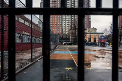 View of concrete schoolyard in New York City through fence
