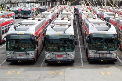 White San Francisco transit buses parked in a large lot.