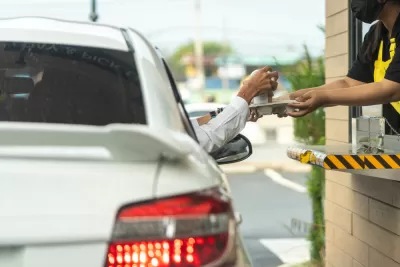 Driver reaching for chagne at drive-through window