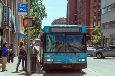 Bus stop in Pittsburgh, Pennsylvania with blue bus and passengers boarding