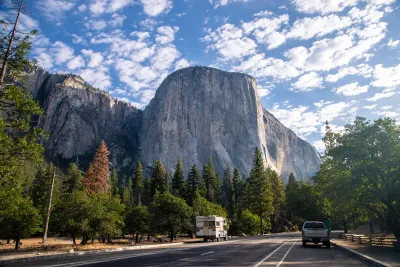 Road in Yosemite National Park with Half Dome rock formation looming above.