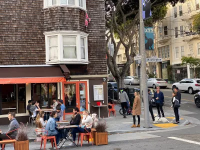 People dining at outdoor tables in temporary setups during or after pandemic in San Francisco, California.