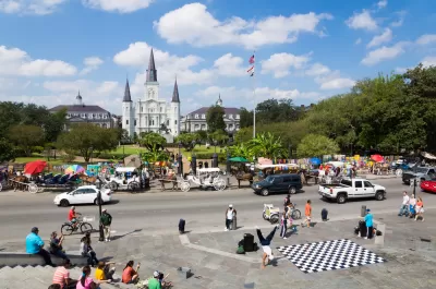 View of Jackson Square, New Orleans with cathedral and street dancers in foreground