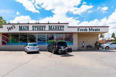 Small town market with "Main Street Market" and "Fresh Meats" signs in green letters.