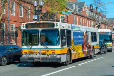 White and yellow MBTA bus in Cambridge, Massachusetts with brick buildings in background
