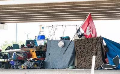 Encampment of unhoused people with tents and draped fabrics in Austin, Texas