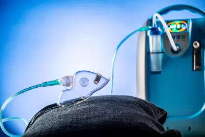 Blue portable oxygen medical device with attached clear mask