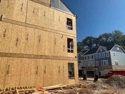 Wood-frame three-story building under construction.