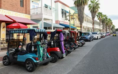 Line of colorful golf carts parked outside restaurant in The Villages, Florida