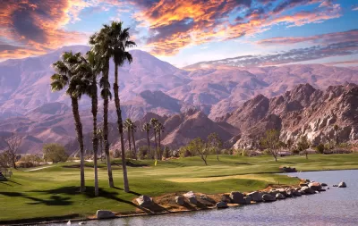 Golf course with palm trees and mountains in background in Palm Springs, California