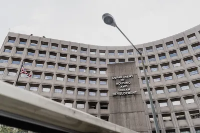 A view from below the HUD. The building is gray with a grid of windows.
