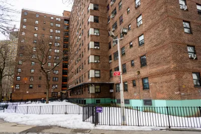 Multistory red brick apartment building in New York City with snow on the ground.