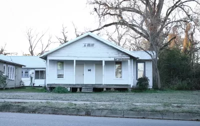 Dilapidated vacant wood slat house painted white in Louisiana