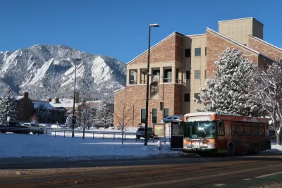 Bus stop in Boulder, Colorado with snowy tree and snowy mountains in background