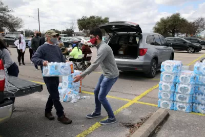 Volunteers wearing masks moving pallets of water bottles during February 2021 storm in Austin, Texas