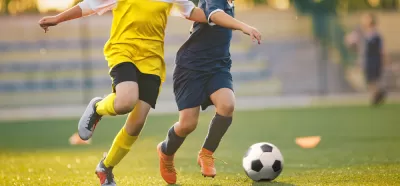 Two soccer players chasing a ball