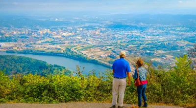 Couple seen from the back looking over Chattanooga, Tennessee from hilltop.
